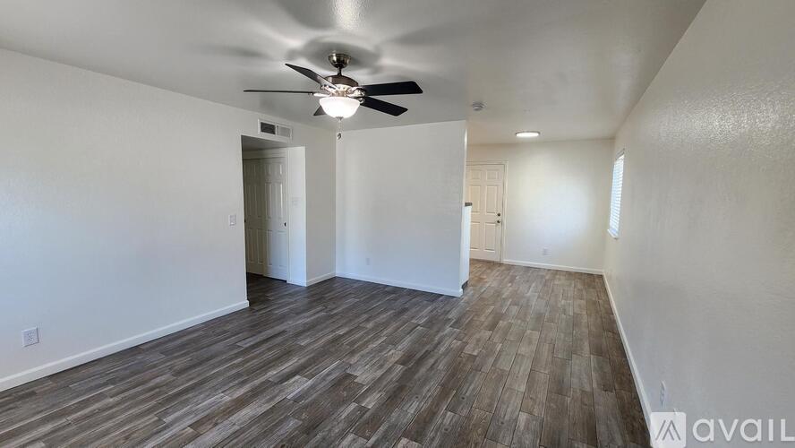 A room with wooden flooring and a ceiling fan.