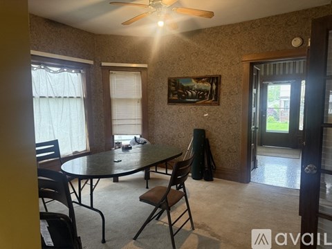 A dining room with a table and chairs.