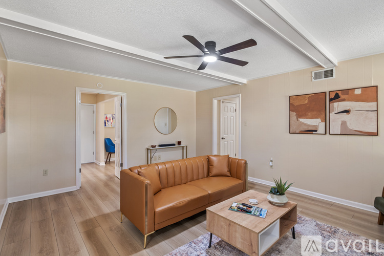 A living room with a brown leather couch and a wooden coffee table.