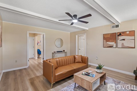 A living room with a brown leather couch and a wooden coffee table.