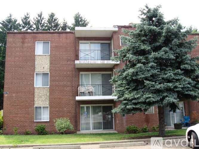 A red brick apartment building with a balcony on the second floor.