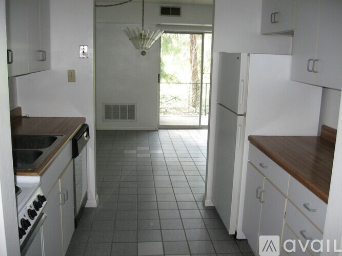 A kitchen with white cabinets and a tile floor.