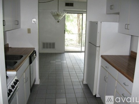 A kitchen with white cabinets and a tile floor.