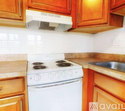 A white stove and oven in a kitchen with wooden cabinets.