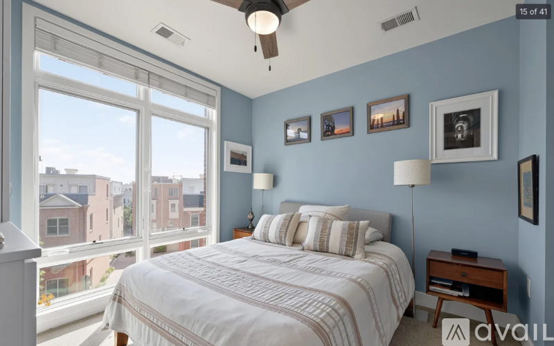 A bedroom with a large bed and a window overlooking a cityscape.