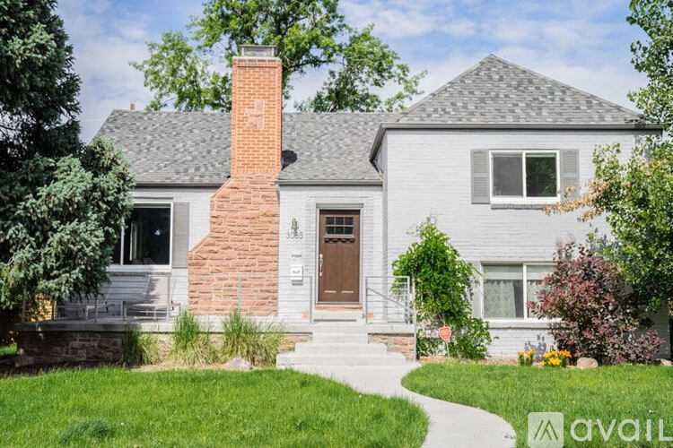 A house with a brick chimney and a grey roof.
