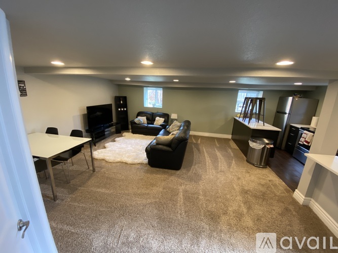 A living room with a black couch and a white table.