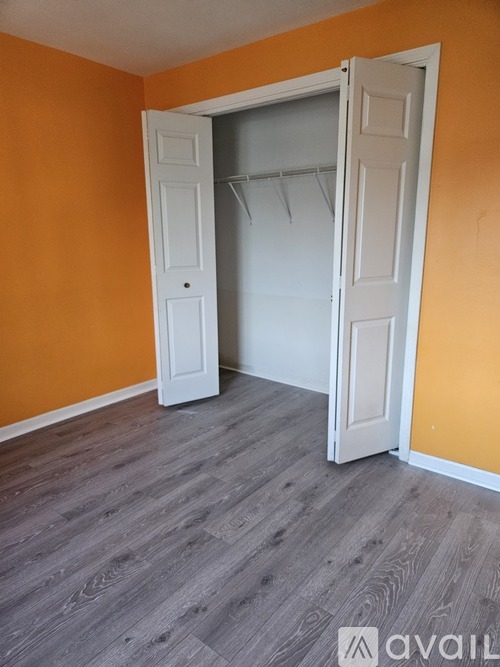A room with a white door and orange walls.