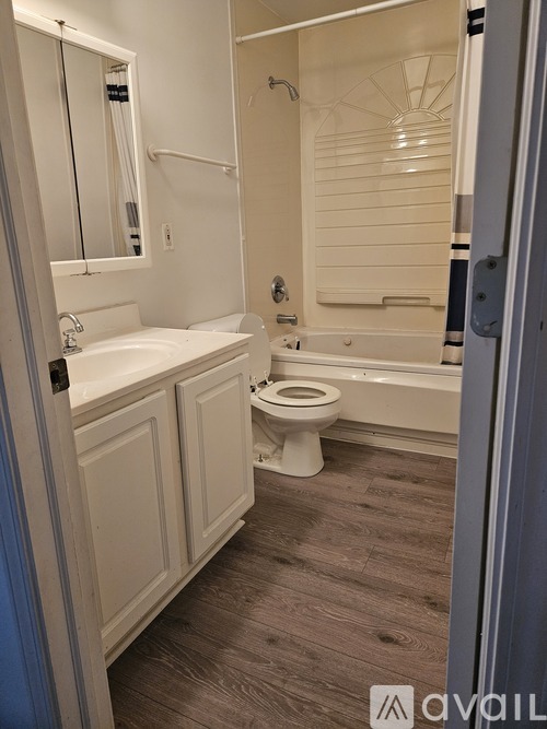 A bathroom with a toilet, sink, and bathtub.