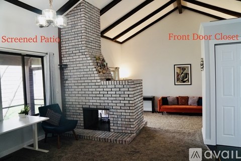 A living room with a brick fireplace and a screened patio.