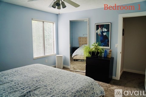 A bedroom with a bed, dresser, and mirror.