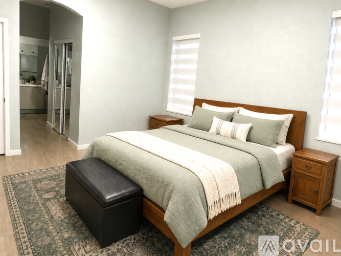 A bedroom with a bed, nightstand, and a bench.