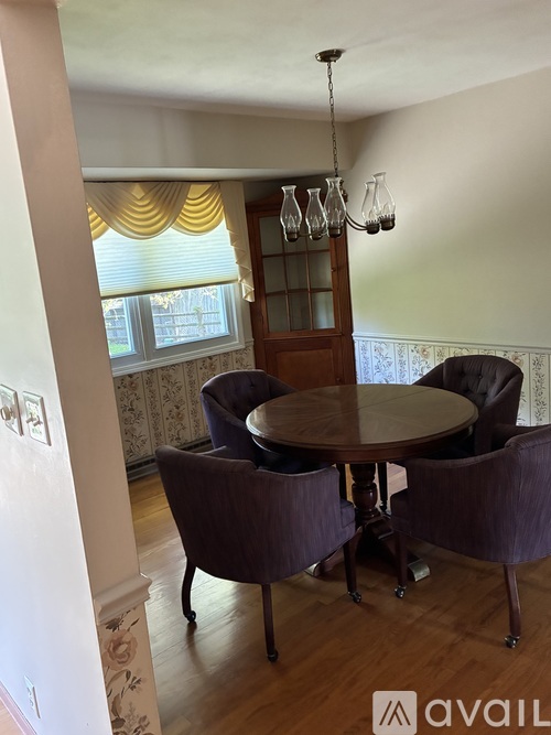 A dining room with a table and chairs.