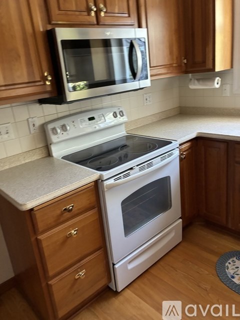 A kitchen with wooden cabinets and a white stove top oven.