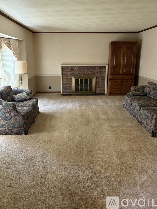 A living room with a fireplace and two couches.