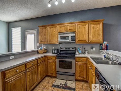 A kitchen with wooden cabinets and a stove top oven.