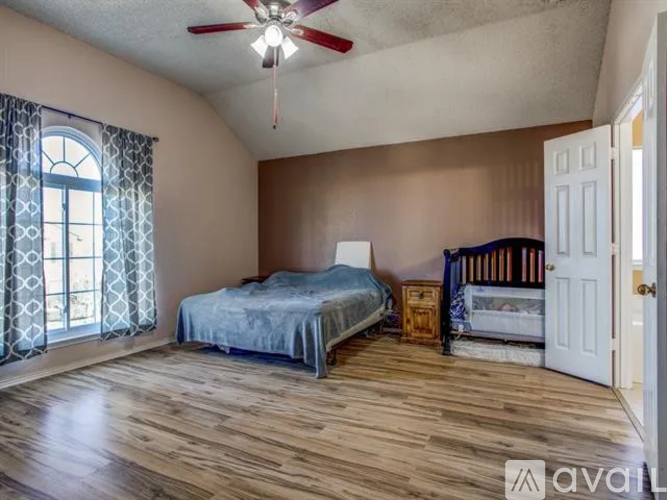 A bedroom with a bed, a dresser, and a crib.