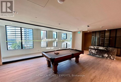 A room with a pool table and a view of the city.