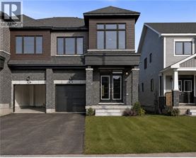 A modern house with a large front yard and a garage.