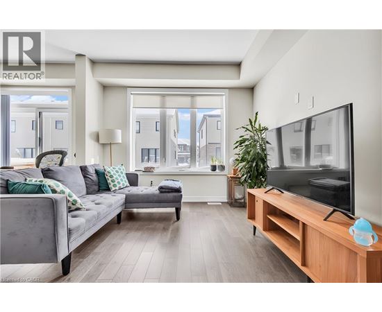 A modern living room with a grey couch and a wooden TV stand.
