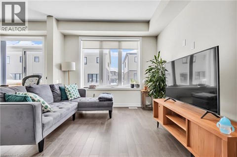 A modern living room with a grey couch and a wooden TV stand.