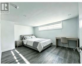 A bedroom with a bed, desk, and chair.