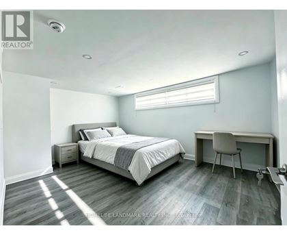 A bedroom with a bed, desk, and chair.