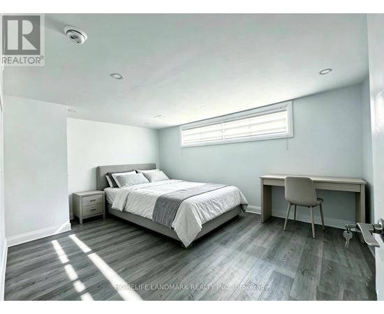 A bedroom with a bed, desk, and chair.