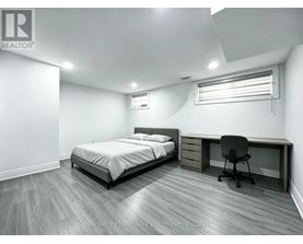 A bedroom with a bed, desk, and chair.