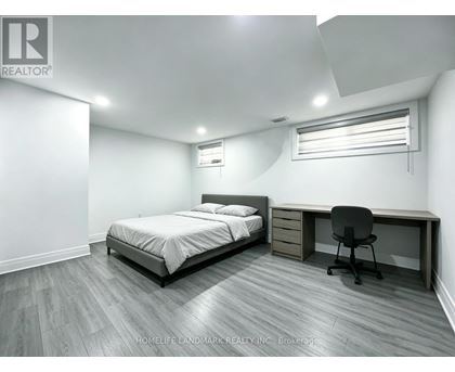 A bedroom with a bed, desk, and chair.
