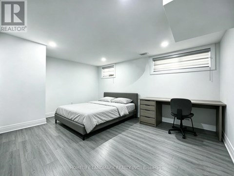 A bedroom with a bed, desk, and chair.
