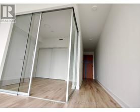 A room with a glass door and wooden flooring.