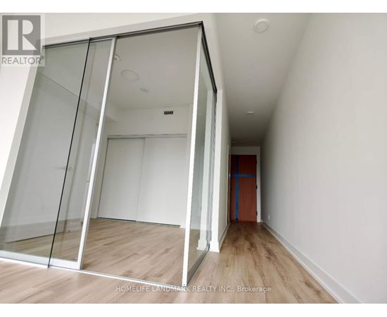 A room with a glass door and wooden flooring.