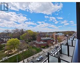 A view from a high vantage point looking down at a street lined with buildings and cars.