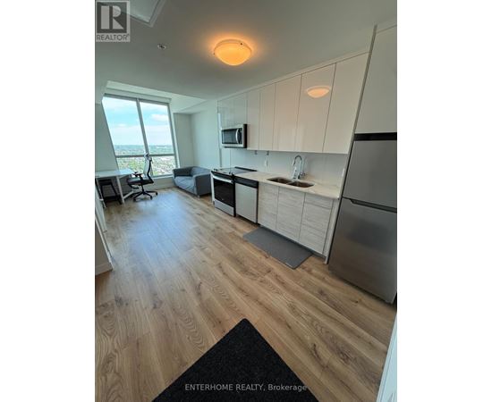 A modern kitchen with wooden floors and white cabinets.