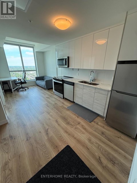 A modern kitchen with wooden floors and white cabinets.