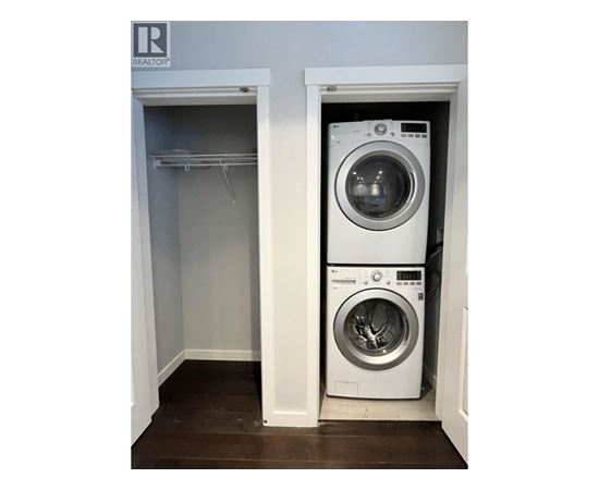 A washing machine is sitting in a small laundry room.