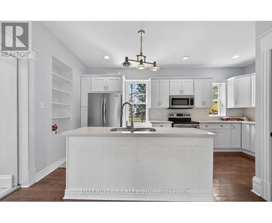 A white kitchen with a sink and a window.