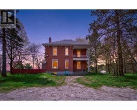 A house with a red brick exterior and a white porch.