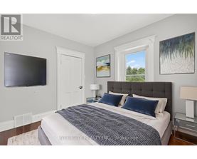 A bedroom with a large bed, a flat screen TV, and two pictures on the wall.