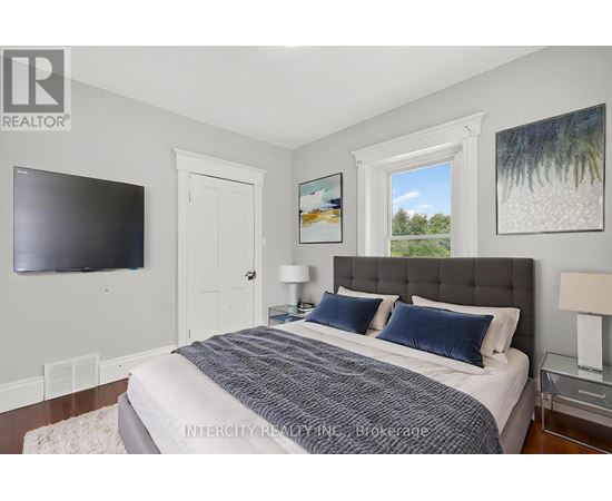A bedroom with a large bed, a flat screen TV, and two pictures on the wall.
