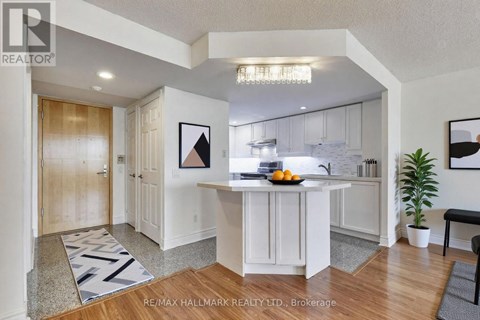 A kitchen with white cabinets and a wooden floor.
