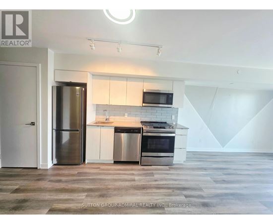 A modern kitchen with a refrigerator, stove, and microwave.