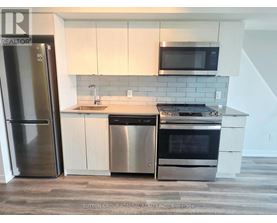 A kitchen with a stainless steel refrigerator, dishwasher, and oven.