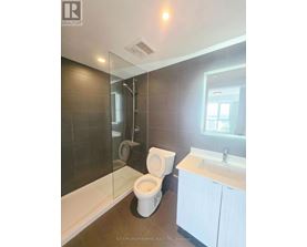 A bathroom with a toilet, sink, and shower.