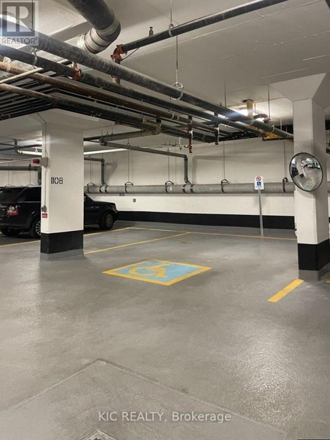 A parking garage with a yellow square on the floor.