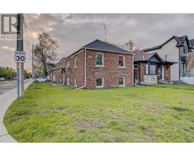 A brick house with a sign that says REALTOR in front of it.