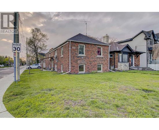 A brick house with a sign that says REALTOR in front of it.