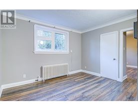 A room with a window, a door, and a radiator.