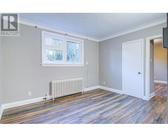A room with a window, a door, and a radiator.